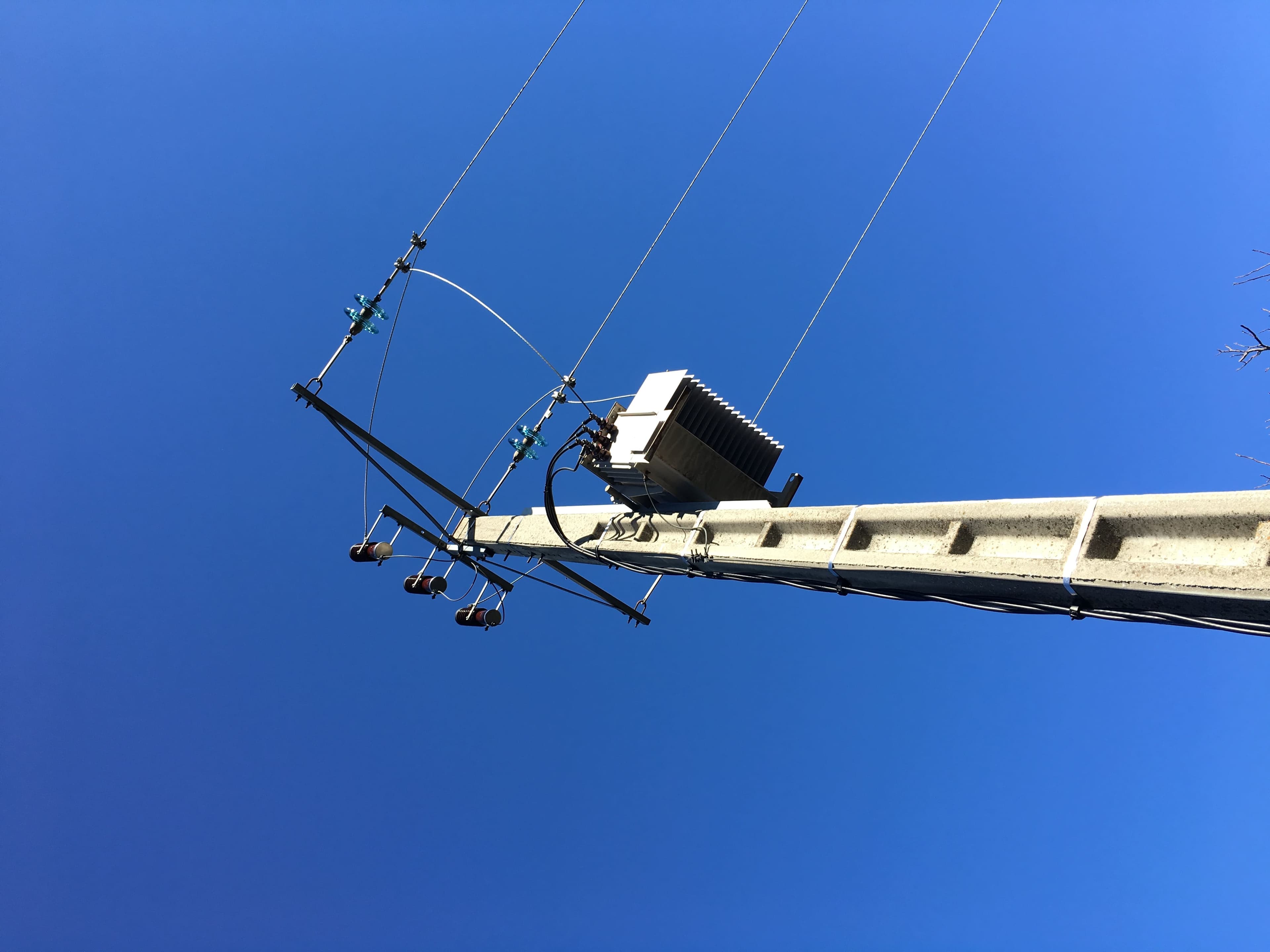 poteau-transformateur-ciel Poteau électrique avec transformateur sous un ciel bleu